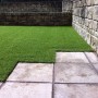 Artificial grass cut into the paving